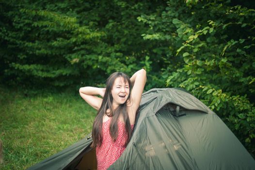 woman among the mountains near the tent enjoys nature. High quality photo