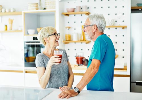 Happy senior couple enjoying breakfast nad healthy juice iafter the exercise in the morning