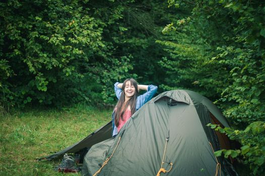 woman among the mountains near the tent enjoys nature. High quality photo