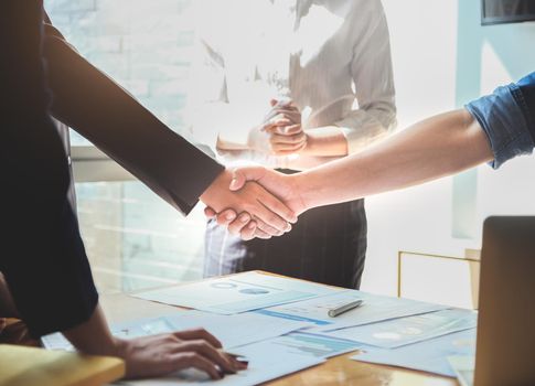 Two businessmen shake hands after a final project agreement is completed to strengthen the business between the two companies.