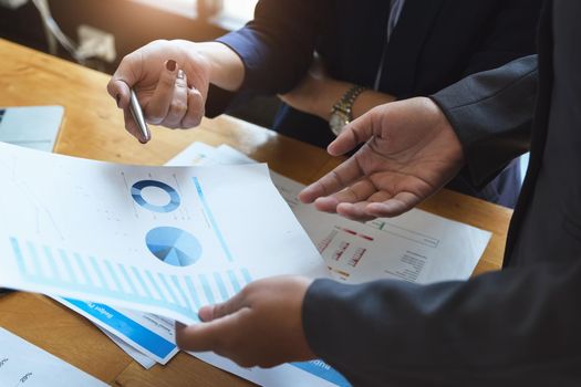 An auditor holds a pen pointing to documents to examine budgets and financial fraud