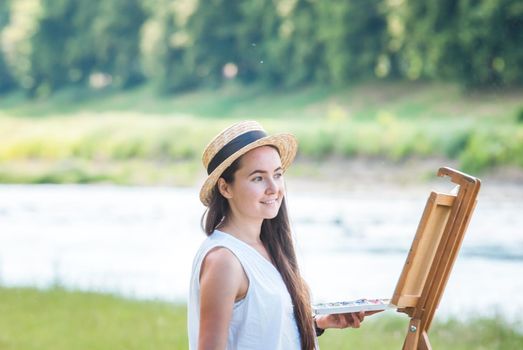 beautiful girl artist outdoor with wooden aesel and watercolor