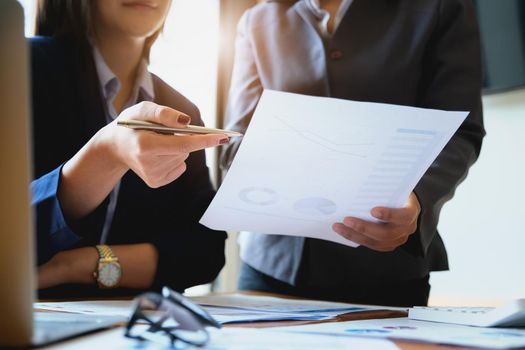 An auditor holds a pen pointing to documents to examine budgets and financial fraud.