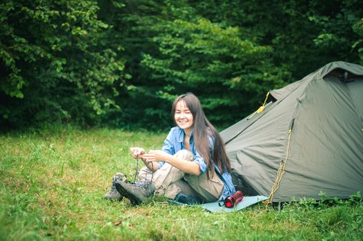 woman among the mountains near the tent enjoys nature. High quality photo