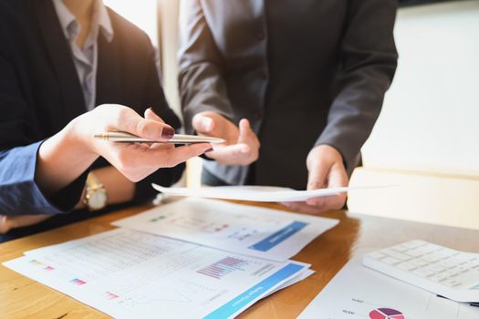 An auditor holds a pen pointing to documents to examine budgets and financial fraud