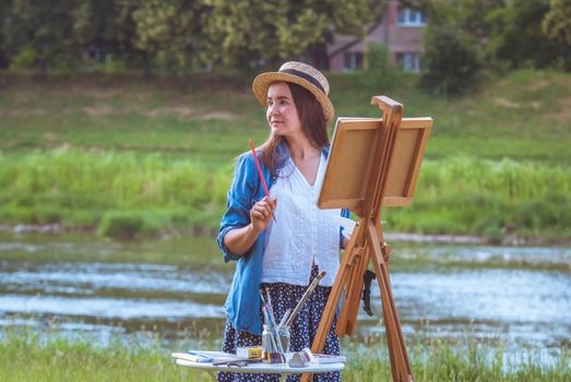 beautiful girl artist outdoor with wooden aesel and watercolor