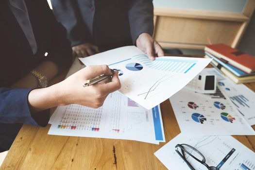 An auditor holds a pen pointing to documents to examine budgets and financial fraud