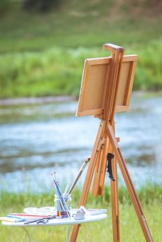 beautiful girl artist outdoor with wooden aesel and watercolor