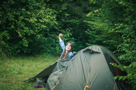 woman among the mountains near the tent enjoys nature. High quality photo