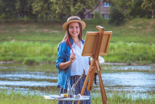 beautiful girl artist outdoor with wooden aesel and watercolor