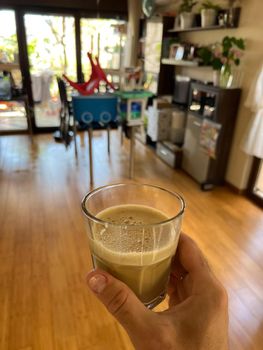 Glass of cappuccino in male hand in cafeteria. High quality photo