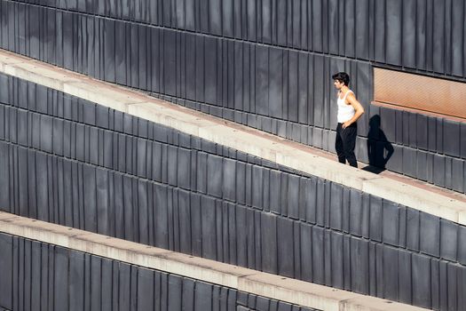 male runner on a break from his training in a concrete jungle, urban sport concept and healthy lifestyle, copy space for text