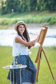 beautiful girl artist outdoor with wooden aesel and watercolor