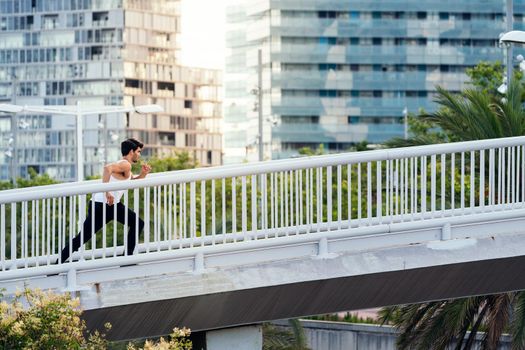 runner running on a city bridge in front of the buildings, urban sport concept and healthy lifestyle, copy space for text