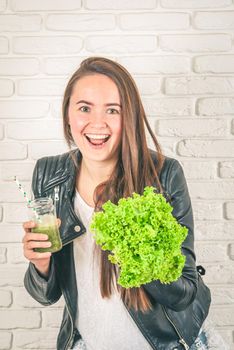 beautiful young smiling woman is drinking green detox shake . High quality photo