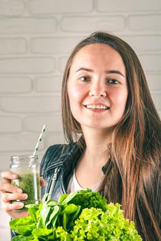 beautiful young smiling woman is drinking green detox shake . High quality photo