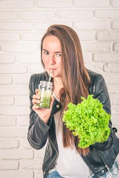 beautiful young smiling woman is drinking green detox shake . High quality photo