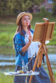 beautiful girl artist outdoor with wooden aesel and watercolor