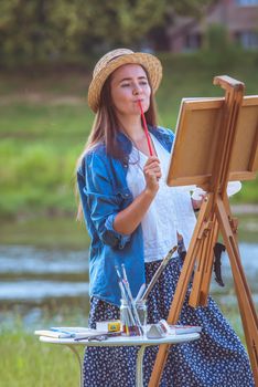 beautiful girl artist outdoor with wooden aesel and watercolor