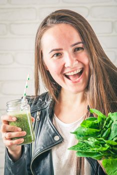 beautiful young smiling woman is drinking green detox shake . High quality photo