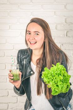 beautiful young smiling woman is drinking green detox shake . High quality photo