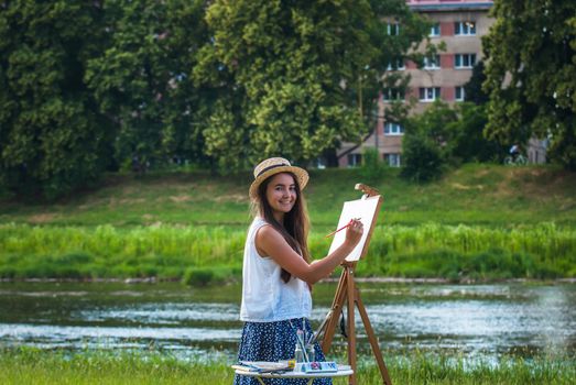 beautiful girl artist outdoor with wooden aesel and watercolor