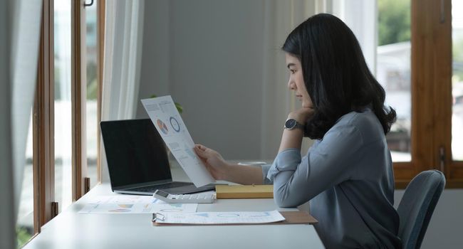 Asian businesswoman working in the office with working documents..