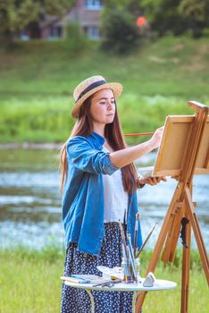 beautiful girl artist outdoor with wooden aesel and watercolor