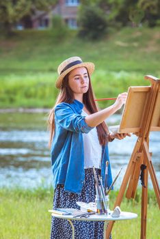 beautiful girl artist outdoor with wooden aesel and watercolor