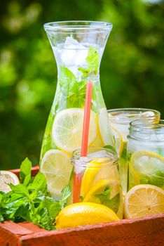 Delicious homemade lemonade in graphene and jars with mint and lemons
