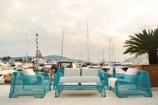 Wicker blue chairs, sofa and table. Summer outdoor furniture on the seashore. High quality photo