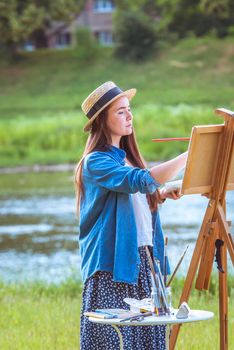 beautiful girl artist outdoor with wooden aesel and watercolor