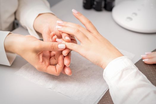 A woman's hand getting a finger massage in a nail salon. Manicure treatment at beauty spa
