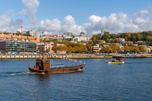 Porto, Portugal - October 23, 2020: Carlota do Douro tourist transport boat sailing on the Douro river showing the ancient city to visitors on an autumn day