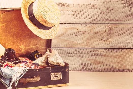 retro bag for summer vocation with photo camera, book and wicker hat. High quality photo