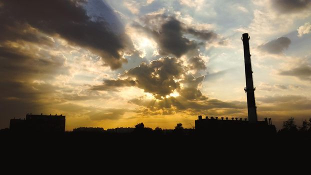 Boiler room chimney on the background of beautiful clouds and sunlight