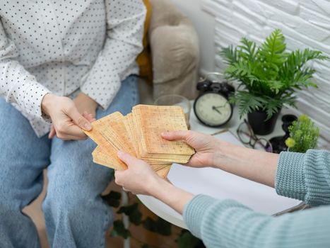 Psychologist uses metaphorical associative cards in a session with a patient. Close-up of female hands