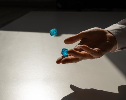 Woman throws a pair of blue transparent dice