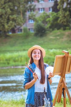 beautiful girl artist outdoor with wooden aesel and watercolor