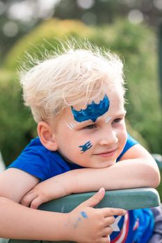 Cute little boy with face paint with batman pattern. Face painting, kid painting face at the birthday party