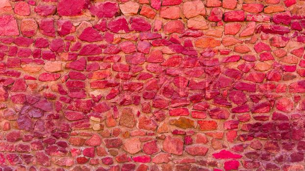 Close-up of the texture of a dark red stone wall.