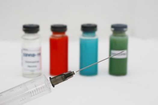 White, red, green and blue ampoule with vaccine.