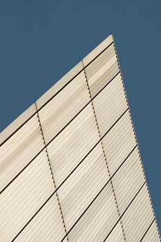 Lines and rectangles texture formed on white metal wall of building with blue sky in background. Abstract modern architecture background.