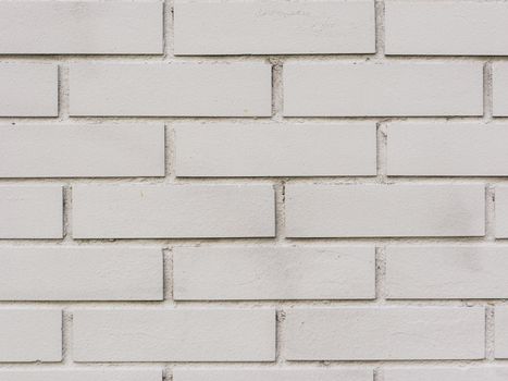 Painted brick wall and weathered sidewalk.