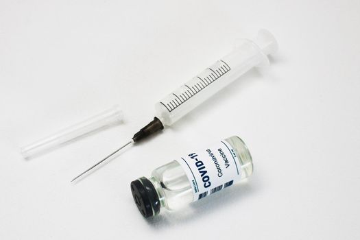 Plastic disposable syringe and ampoule with covid-19 vaccine.