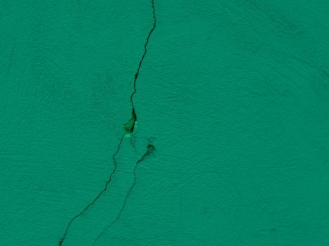 Cracked plaster on the wall. Green plaster wall texture.