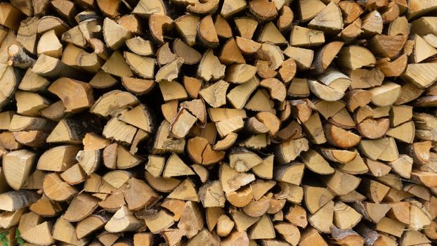 Wall of firewood, Wooden background. Natural texture. Background of dry chopped firewood logs in a pile.