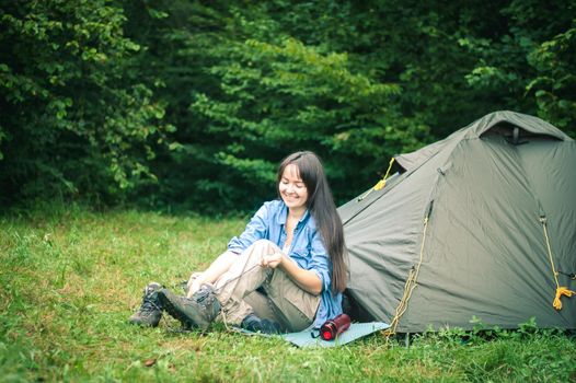 woman among the mountains near the tent enjoys nature. High quality photo