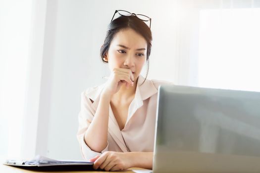 new normal, a businesswoman uses a computer to work for a company Via the internet on your desk at home.