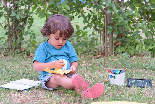 Elementary school age boys love to paint in parks. Boys are drawing pictures as an outdoor hobby. Concept of education outside of school